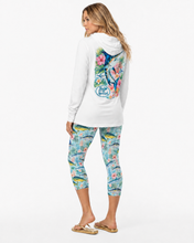 Load image into Gallery viewer, A woman modeling a white long-sleeve Reel Mermaid Tropical Marlin hooded top and Bluewater Bloon printed capri leggings from the back, showing a large multicolor floral graphic on the back of the top and a blue Reel Mermaid logo. The leggings have a blue, pink, and yellow tropical fish pattern.lin 